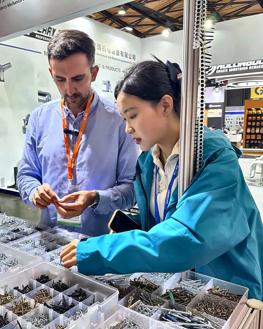 Nacho, de NAMAR Global, revisando muestras de tornillos con una proveedora en una feria en China